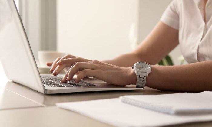 Womans hands typing laptop workplace LR